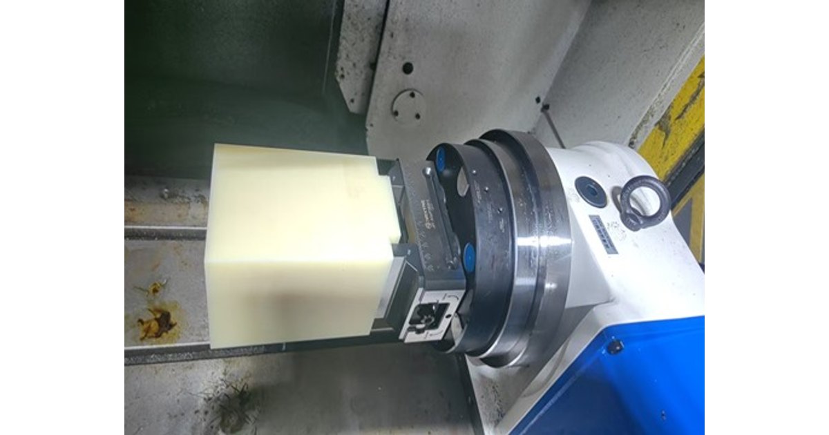 Rectangular block clamped in a self-centering vise on a rotary axis